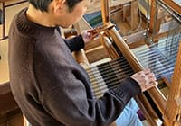 筬（おさ）で打ち込む